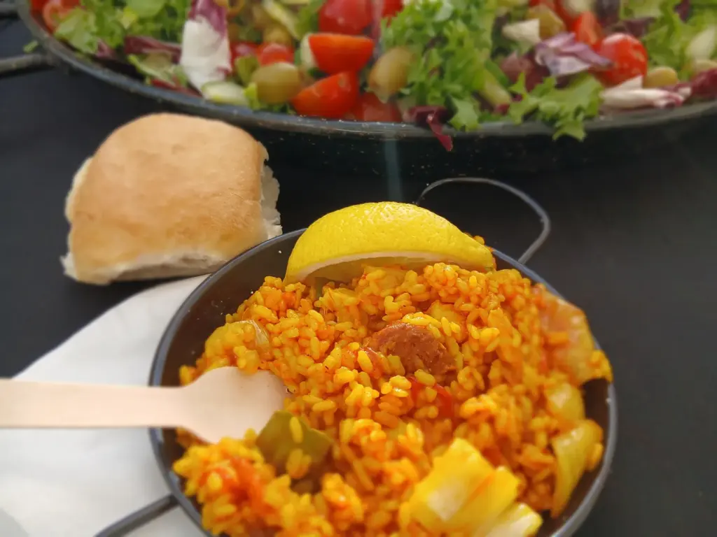 Paella catering for small gardens served fresh with lemon, bread roll and Mediterranean salad