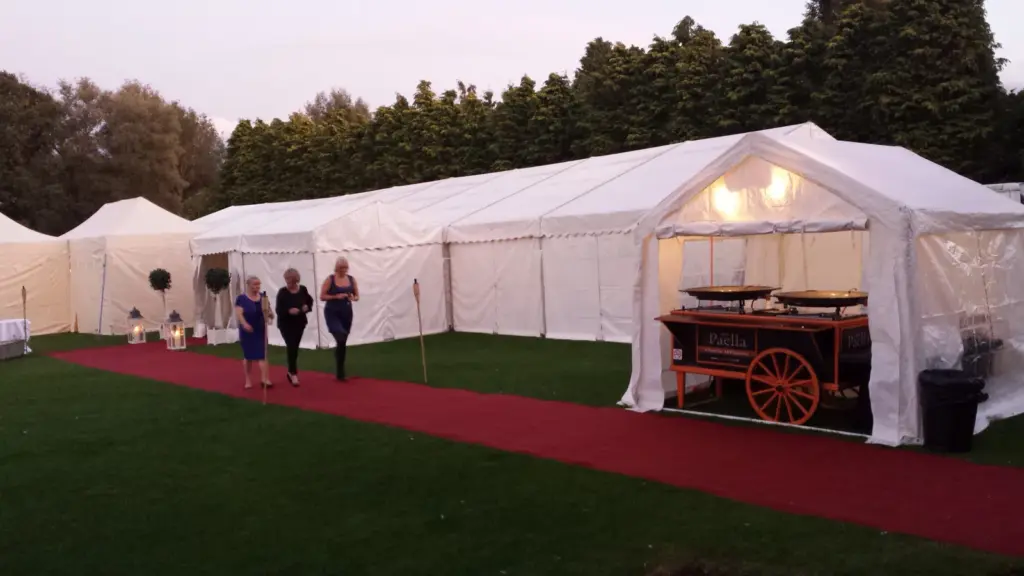 Mobile paella catering setup beside a large event marquee