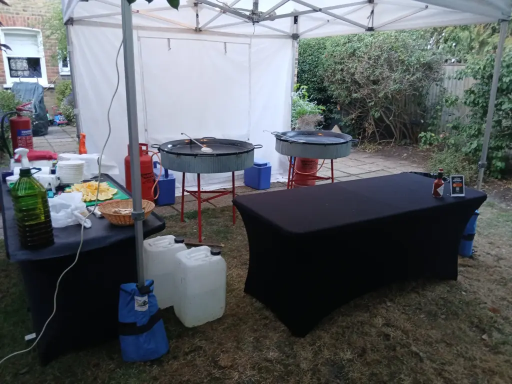 Two large cooking pans set up beneath our white gazebo